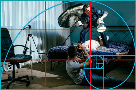 Fotografi av en fotograf som tar bilde av en mann som holder lyskilder. Tenk på posisjoneringen til kamera under videoproduksjonen. 